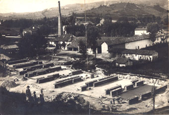 Nella foto: la Fornace Casetta in un’immagine dei primi anni del Novecento. In primo piano, i mattoni stoccati sul piazzale e, sullo sfondo, l’antica ciminiera, allora alta oltre 40 metri Fornace Casetta Alba - Immagine del '900